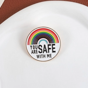 Badge en émail arc-en-ciel avec texte YOU ARE SAFE WITH ME sur une assiette blanche