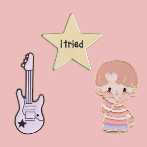 Three-piece enamel pin set featuring a white guitar, cartoon boy, and star badge
