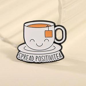 Cute tea cup enamel pin with SPREAD POSITIVITEA slogan on a minimalist background