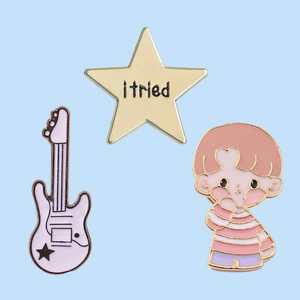 Detailed view of 3pcs white guitar, gold star, and cartoon boy enamel lapel pin set