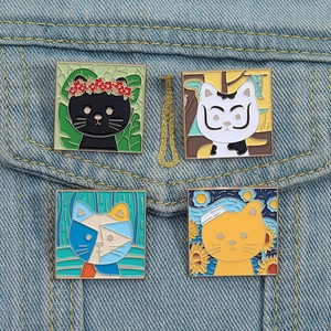 Detailed close-up of four artistic cat enamel pins pinned on a blue denim jacket pocket