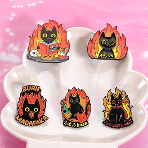 Detailed macro view of five black cat enamel pins on a white shell-shaped tray