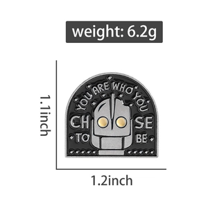 Detail shot of robot enamel pin with text You Are Who You Choose To Be and dimensions