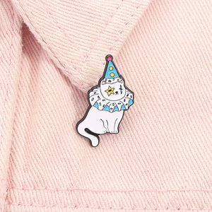 Détail du pin's chat clown blanc avec chapeau à pois bleus sur tissu en jean rose