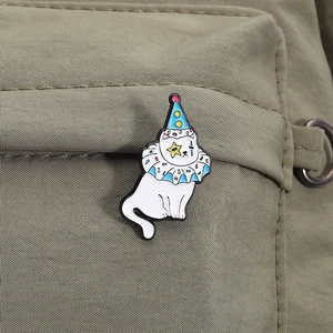Détail d'un pin's en émail chat de cirque clown sur un sac en toile vert olive