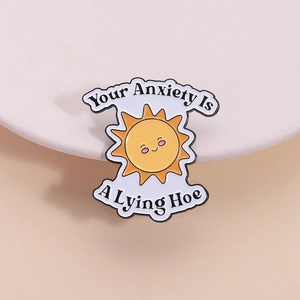 Broche soleil et nuage en émail avec citation inspirante sur fond crème minimaliste