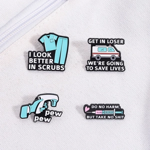 Medical enamel pins set including ambulance and scrubs designs on white fabric