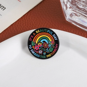 Enamel brooch with colorful rainbow and flower patterns on a black circular metal base