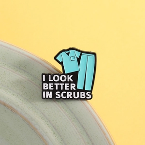 Creative blue scrub suit enamel pin with I LOOK BETTER IN SCRUBS text on yellow background