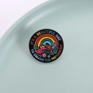 Detailed close-up of a floral enamel pin with the empowering message to smash the patriarchy
