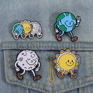 Macro shot of cartoon earth sun and moon enamel pins pinned on a blue denim jacket