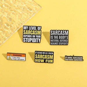Macro shot of five enamel lapel pins with sarcastic quotes on a yellow background