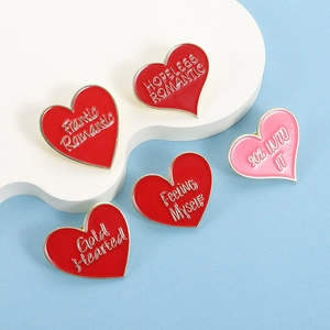 Set di cinque spille smaltate a cuore rosso con bordo dorato su supporto bianco