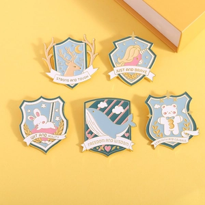 Set of 5 enamel shield pins with animal designs on yellow background and gift box