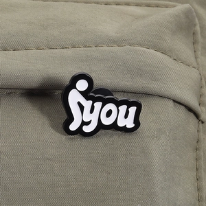 Makro-Detail des Emaille-Pins mit Syou-Schriftzug auf olivgrünem Textilhintergrund