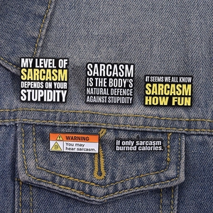 Set of 5 enamel pins with sarcastic English quotes on blue denim jacket pocket