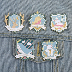 Detailed set of 5 animal shield enamel pins with inspirational slogans on blue denim