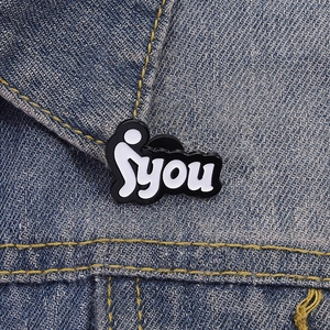 Detailaufnahme einer kreativen schwarz-weißen Emaille-Anstecknadel an einer Jeansjacke