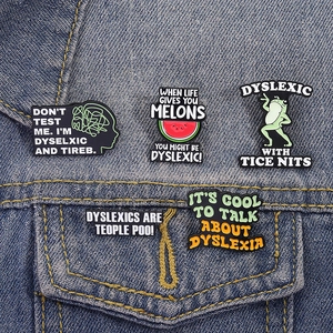 Détail de cinq broches en émail sur la poche d'une veste en jean bleue classique