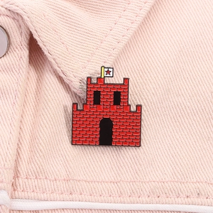 Detail of red castle enamel pin with white star flag on pink denim jacket pocket