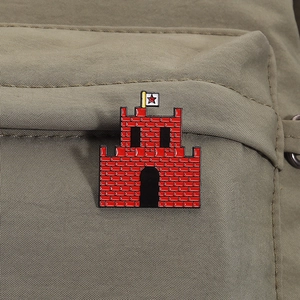 Macro detail of red castle enamel pin with red star flag on khaki fabric texture