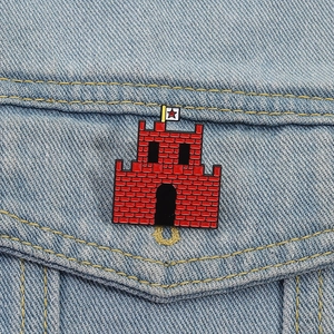Red castle enamel brooch with star flag pinned on a blue denim jacket pocket