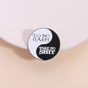 Yin Yang enamel brooch with 'Do No Harm' text on a minimalist geometric metal badge
