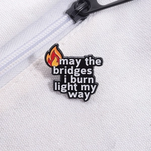 Close-up of flame badge on canvas with "may the bridges i burn light my way" text