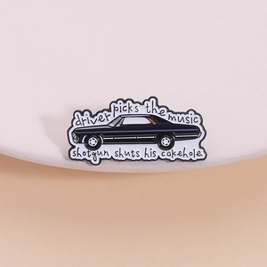 Black muscle car enamel pin with 'Driver picks the music' text on minimalist display