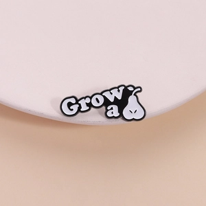 Minimalist black and white enamel pear lapel pin featuring creative Grow a text design