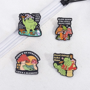 Lot de quatre pin's émaillés grenouille et champignon avec citations sur toile