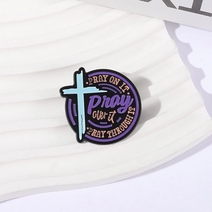 Detail of round enamel faith brooch with Pray On It text and blue cross design
