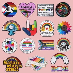 Lot de 15 broches émaillées colorées avec motifs arc-en-ciel sur un fond rose doux