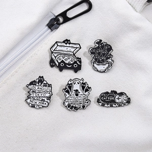 Set of five cute cartoon black cat metal pins on a white canvas bag accessory