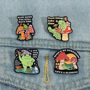 Détails de quatre pin's en émail grenouille et champignon sur tissu en jean bleu