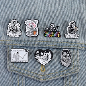 Set of gothic skull enamel pins with dark humor quotes styled on a denim jacket pocket