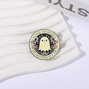 Pin de esmalte de fantasma con flores y frase 'Living the Dream' sobre fondo blanco