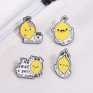 Détail de quatre épingles en émail citron mignonnes avec des jeux de mots sur toile