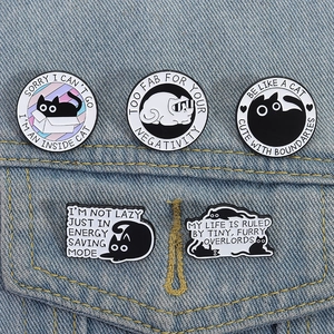 Detailansicht von 5 Cartoon-Emaille-Pins mit schwarzen Katzen auf einer Jeansjackentasche