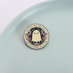 Pin de esmalte fantasma con flores y mariposa, diseño de texto Living the Dream