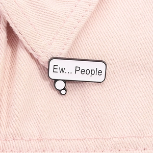 Detail of Ew People speech bubble enamel pin pinned on pink denim fabric texture