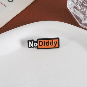 Détail du badge en émail No Diddy sur une assiette blanche et un décor en cuir