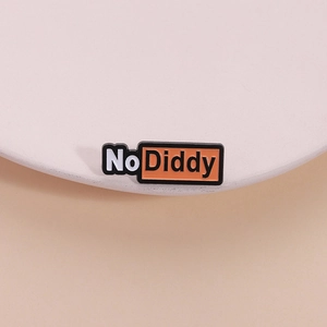 Épingle émaillée minimaliste avec logo No Diddy sur un fond crème aux tons doux