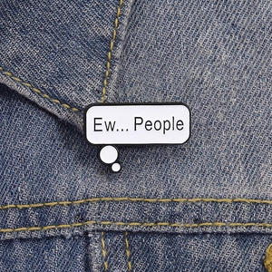 Creative enamel pin with 'Ew... People' text on white rectangle for denim jackets