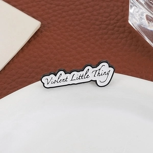Broche géométrique minimaliste en émail avec texte Violent Little Thing sur badge blanc