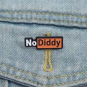 Détail du badge No Diddy fixé à une boutonnière sur un tissu en denim bleu clair
