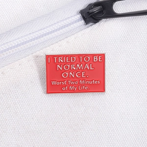 Macro-opname van rode emaille speld met grappige tekst op een witte canvas tas
