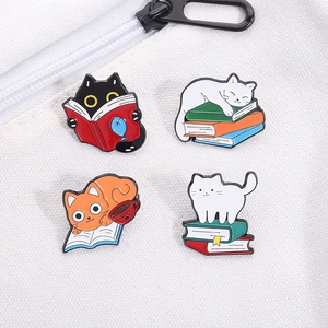 Set of four cute cartoon cat enamel pins featuring reading and sleeping themes on canvas