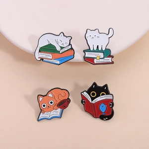 Set of four unique metal enamel cat pins featuring reading cats on colorful books