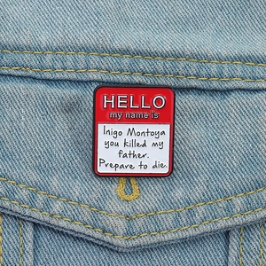 Macro detail of red and white Hello My Name Is enamel pin on blue denim jacket pocket